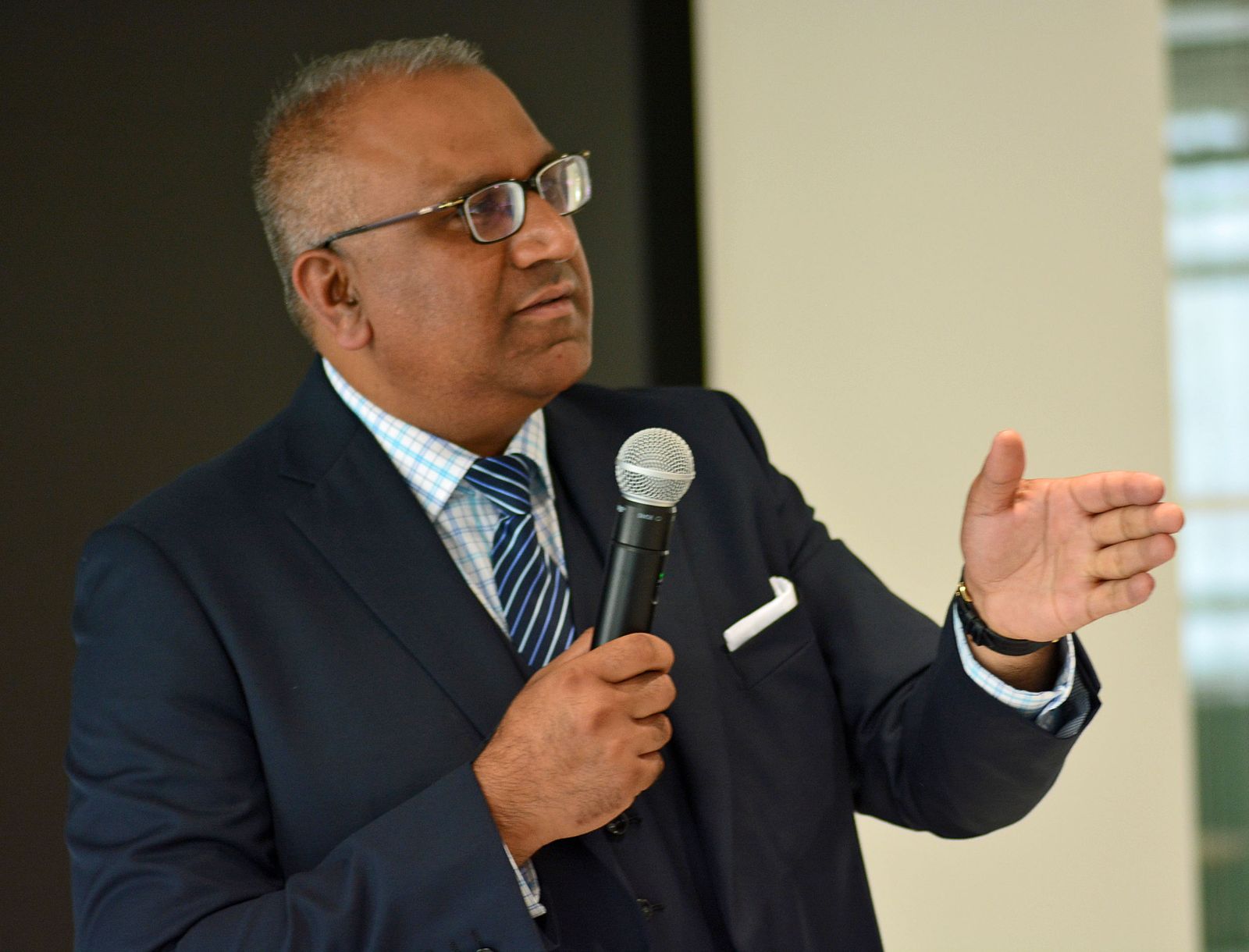 Safaraz Ali MBE speaking with a microphone