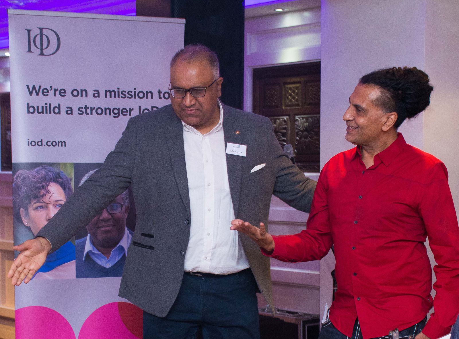 Safaraz Ali MBE talking with a guest at a business event