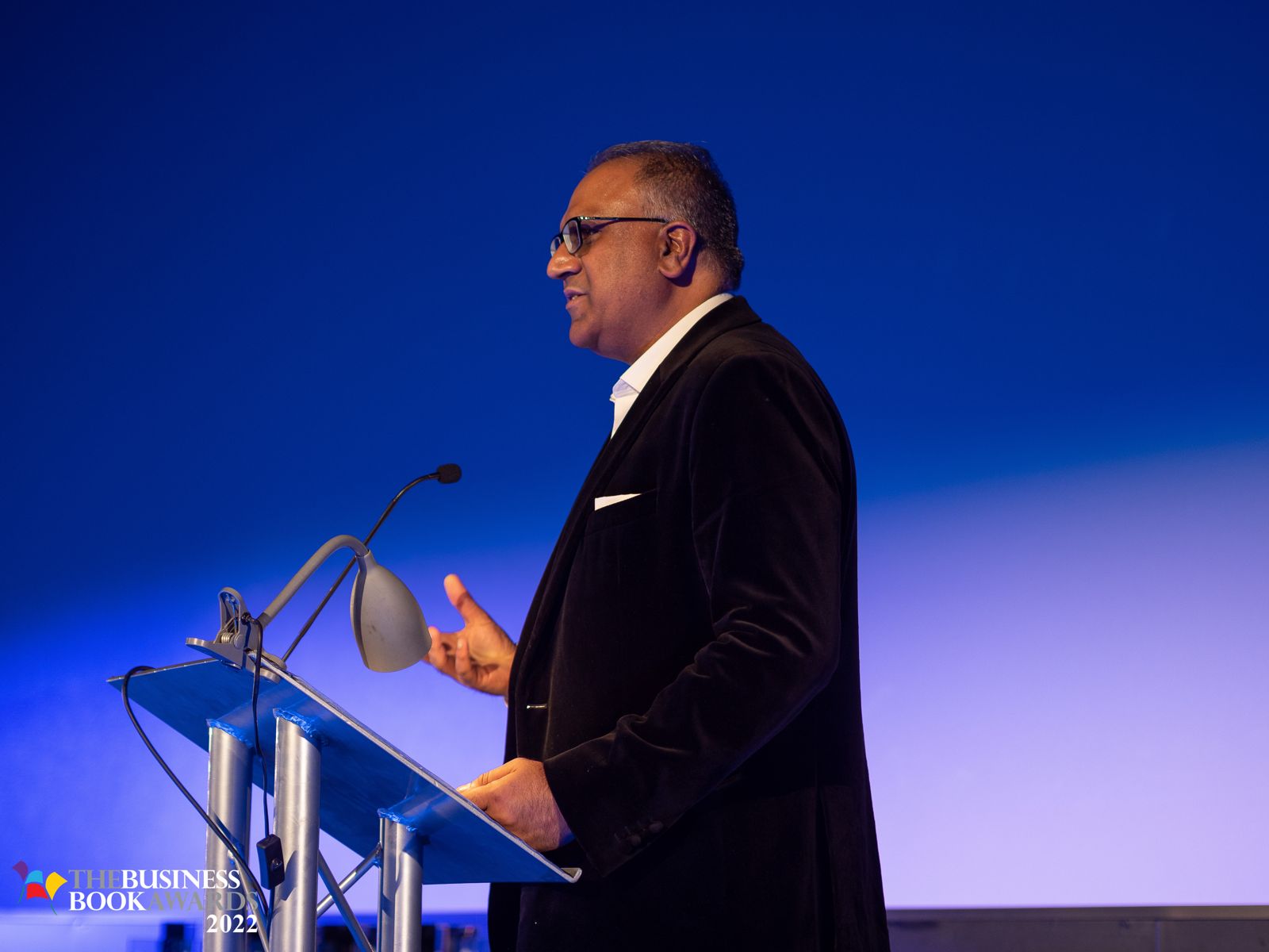 Safaraz Ali MBE speaking from a podium