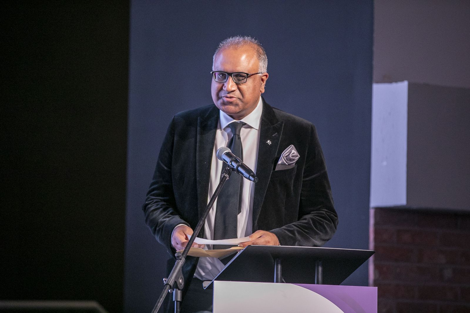 Safaraz Ali MBE speaking at a podium