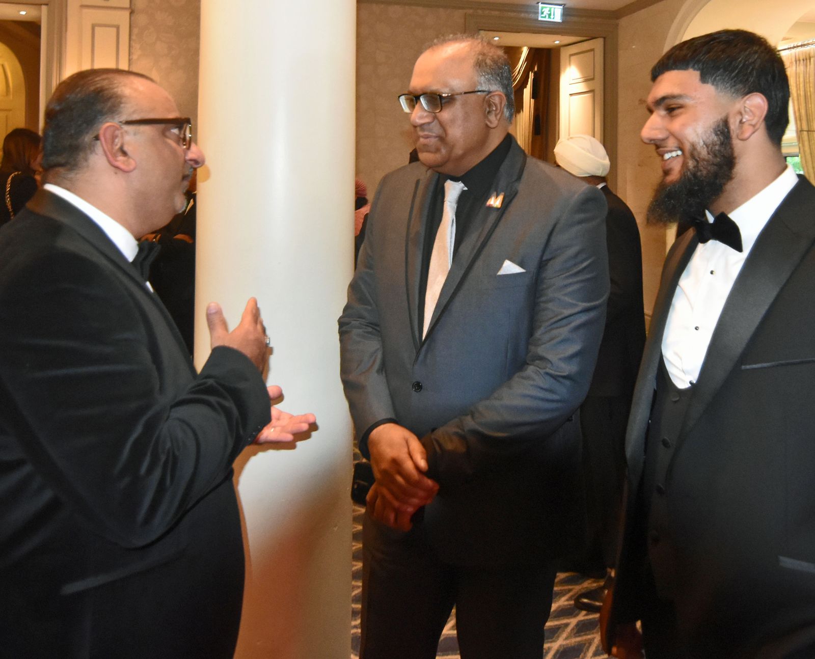 Safaraz Ali MBE talking with guests at an event