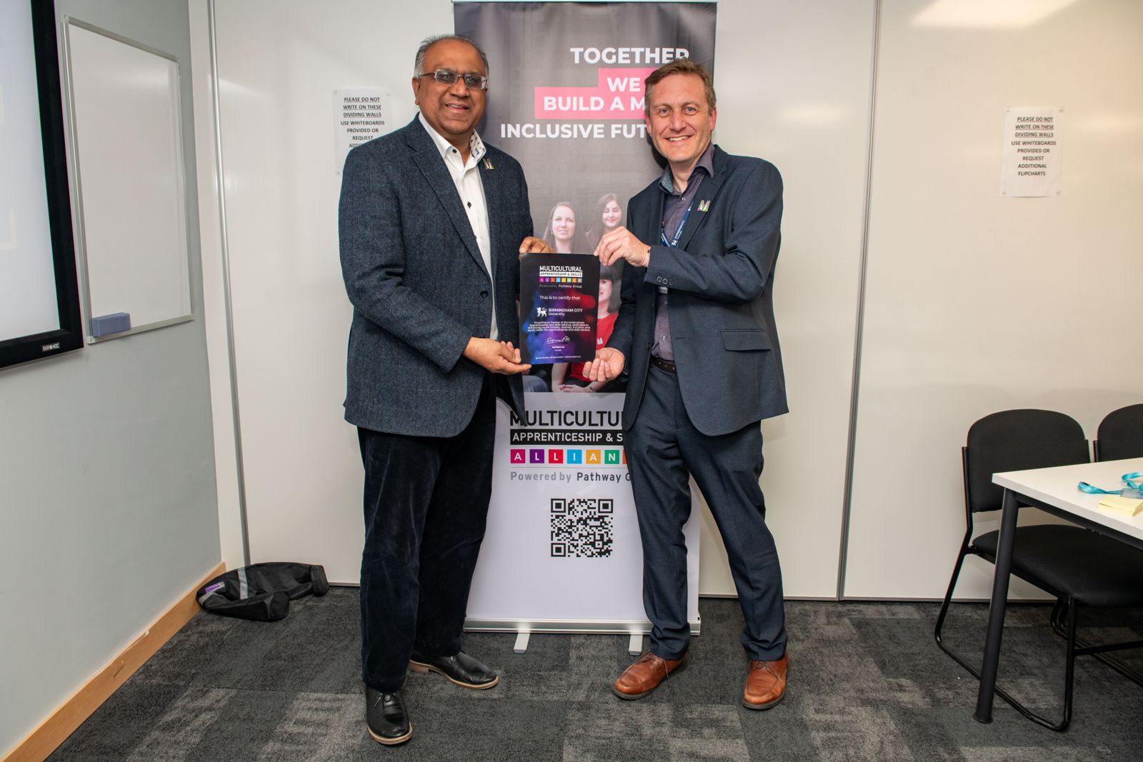 Safaraz Ali MBE presenting an award at a training event