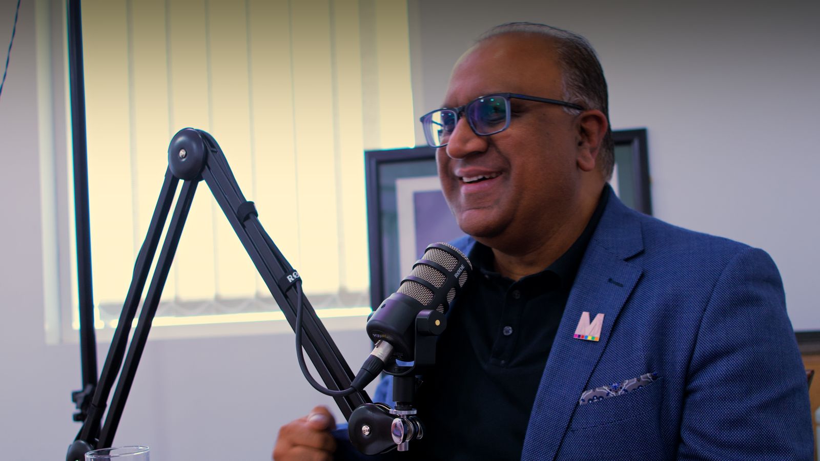 Safaraz Ali MBE smiling during a podcast recording
