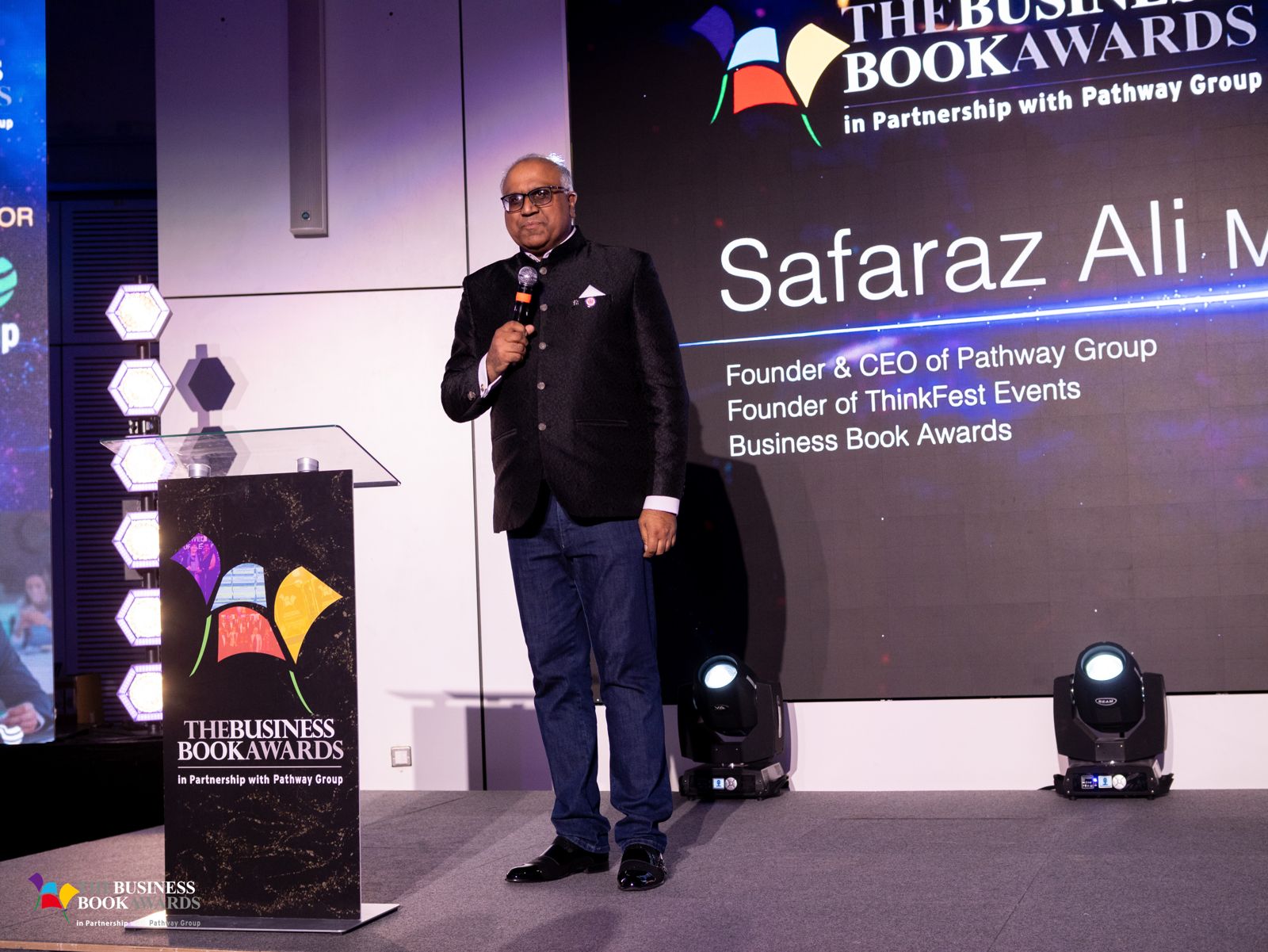 Safaraz Ali MBE speaking on stage at an awards event